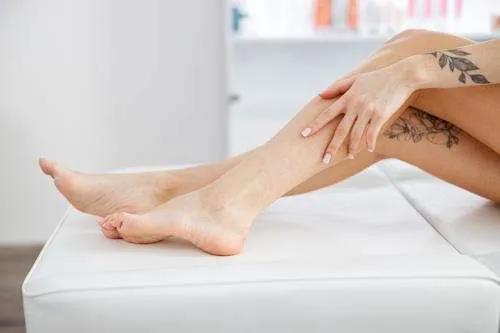Medical professional performing sclerotherapy, injecting a solution into a varicose vein, with the vein and syringe in focus against a clinical background.
